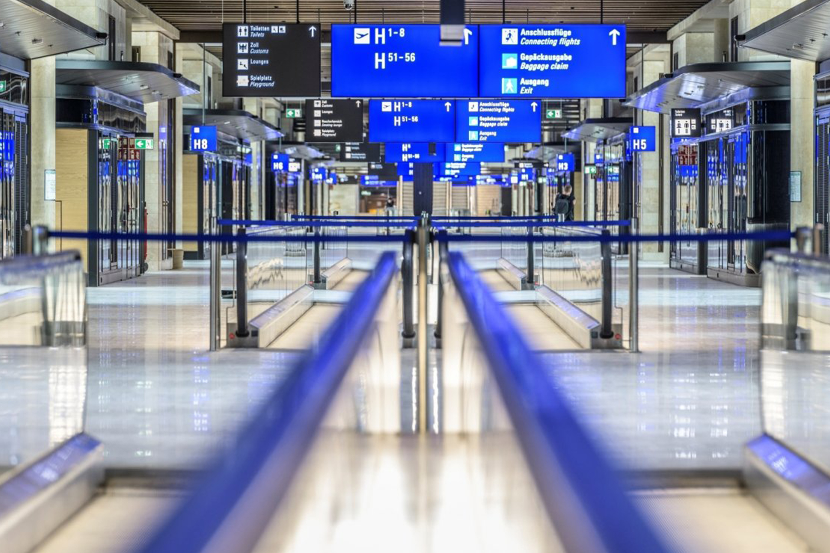 Flugsteig im Frankfurt Airport Terminal 3 mit Laufb&auml;ndern, blauen Wegweisern zu den Gates H1&ndash;H8 sowie Hinweisen zu Anschlussfl&uuml;gen, Gep&auml;ckausgabe und Ausgang