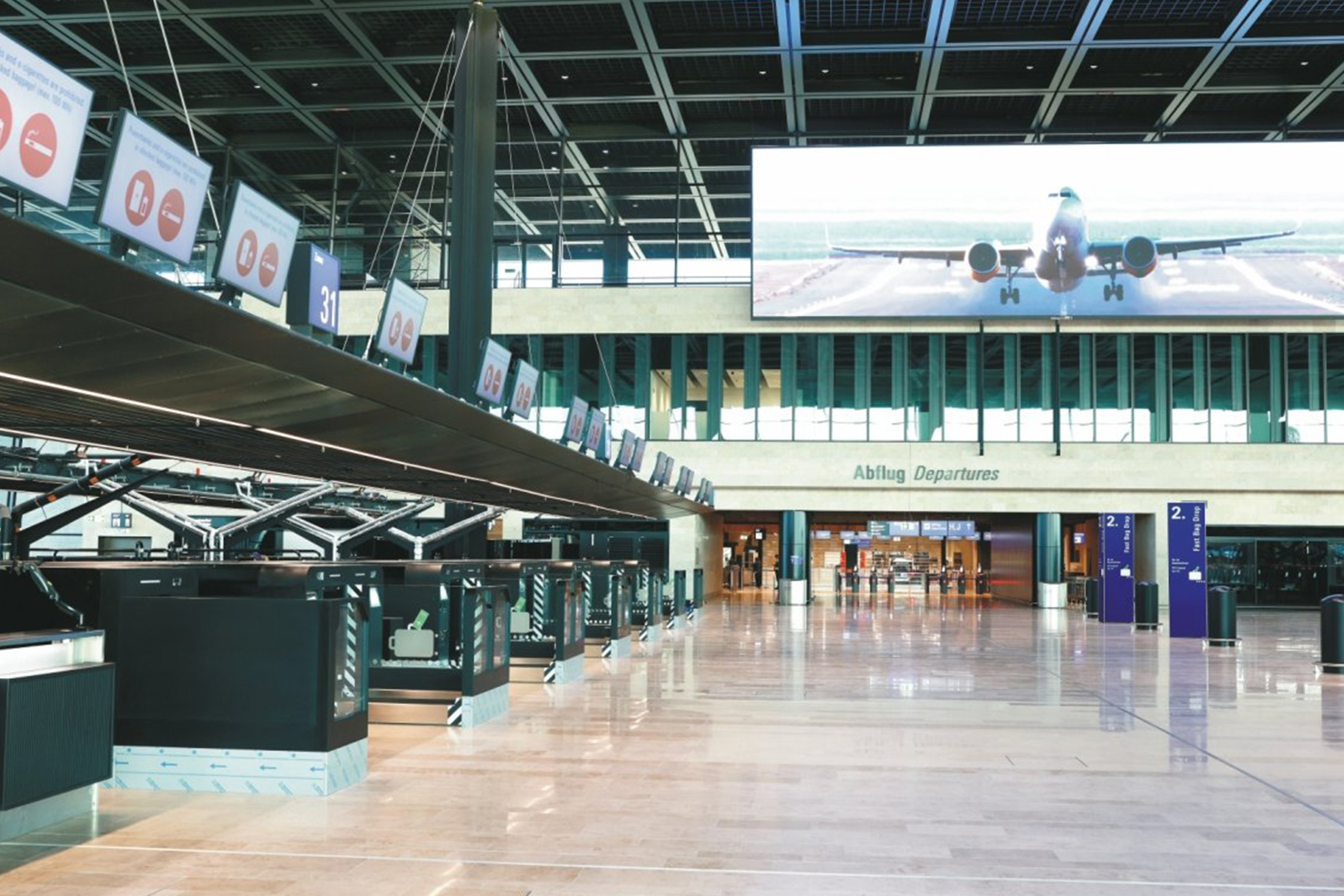 Check-in-Halle im Frankfurt Airport Terminal 3 mit Reihe moderner Check-in-Schalter, gro&szlig;em Bildschirm mit Flugzeugmotiv und Beschriftung &bdquo;Abflug Departures&ldquo; im Hintergrund
